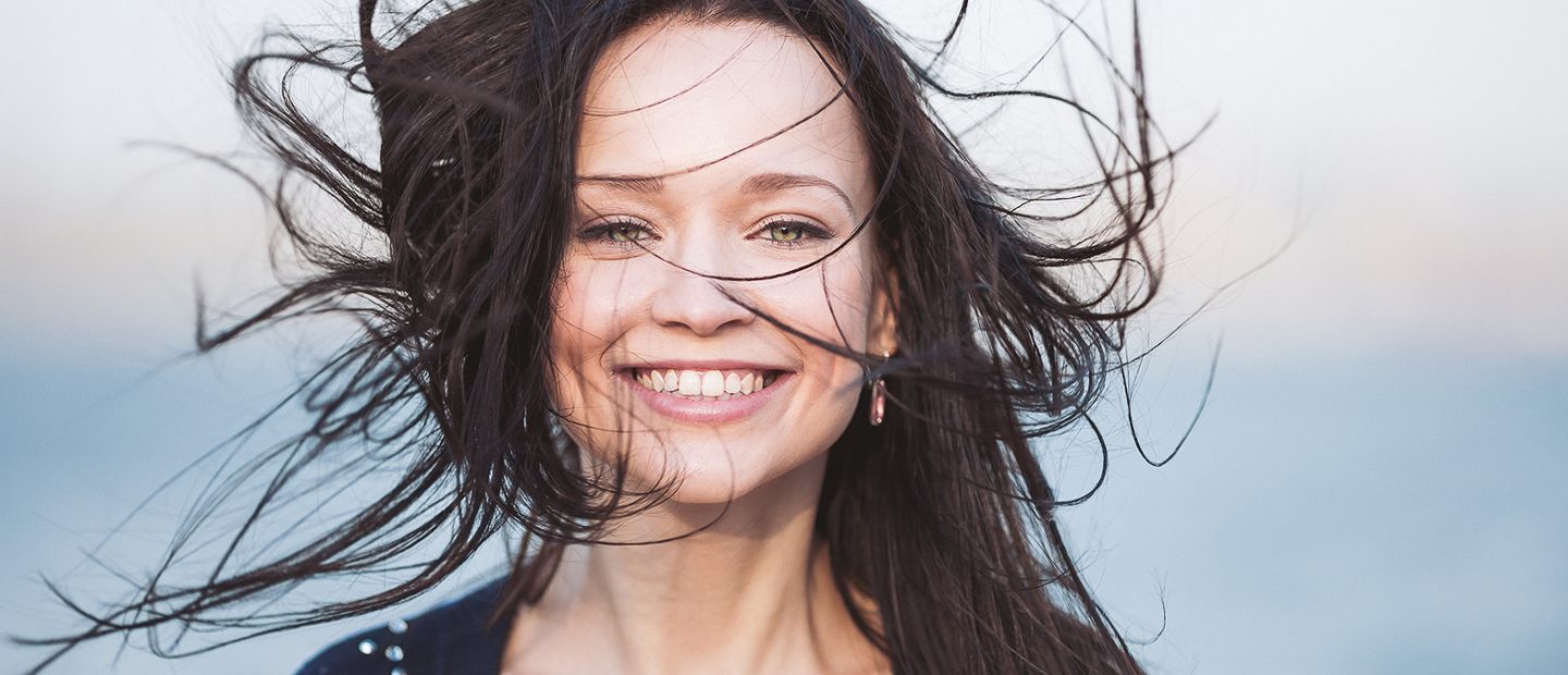 A portrait of smiling cute young girl with long black hair