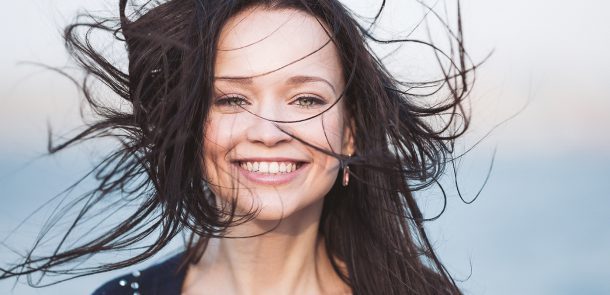 A portrait of smiling cute young girl with long black hair
