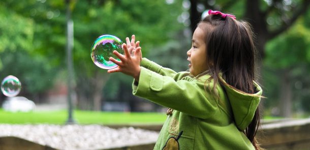 girl playing with bubbles on an overcast day