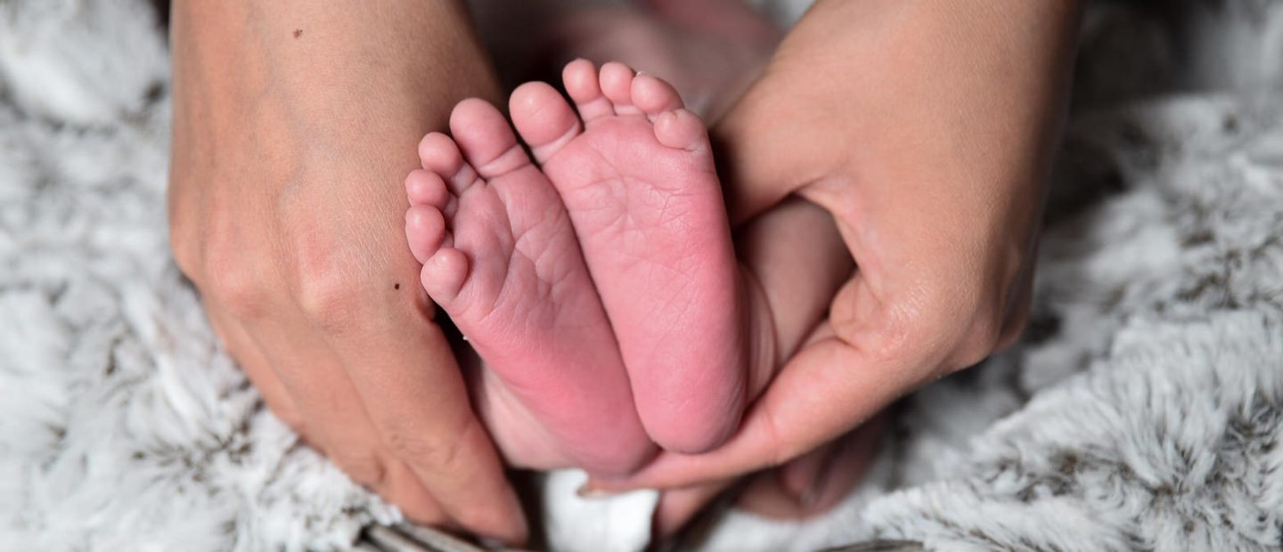 Hands holding tiny baby feet