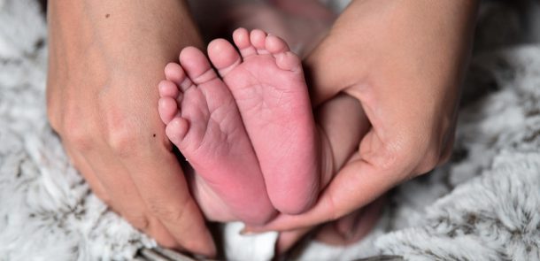 Hands holding tiny baby feet
