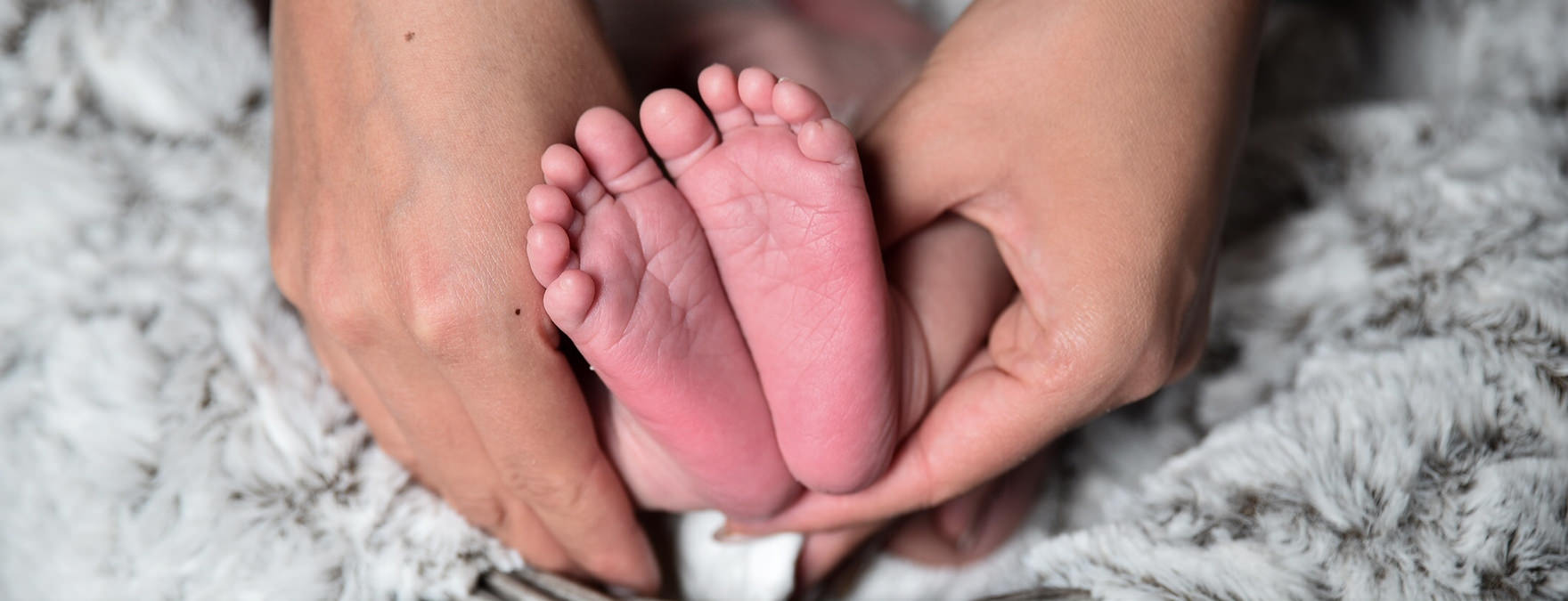 Hands holding tiny baby feet